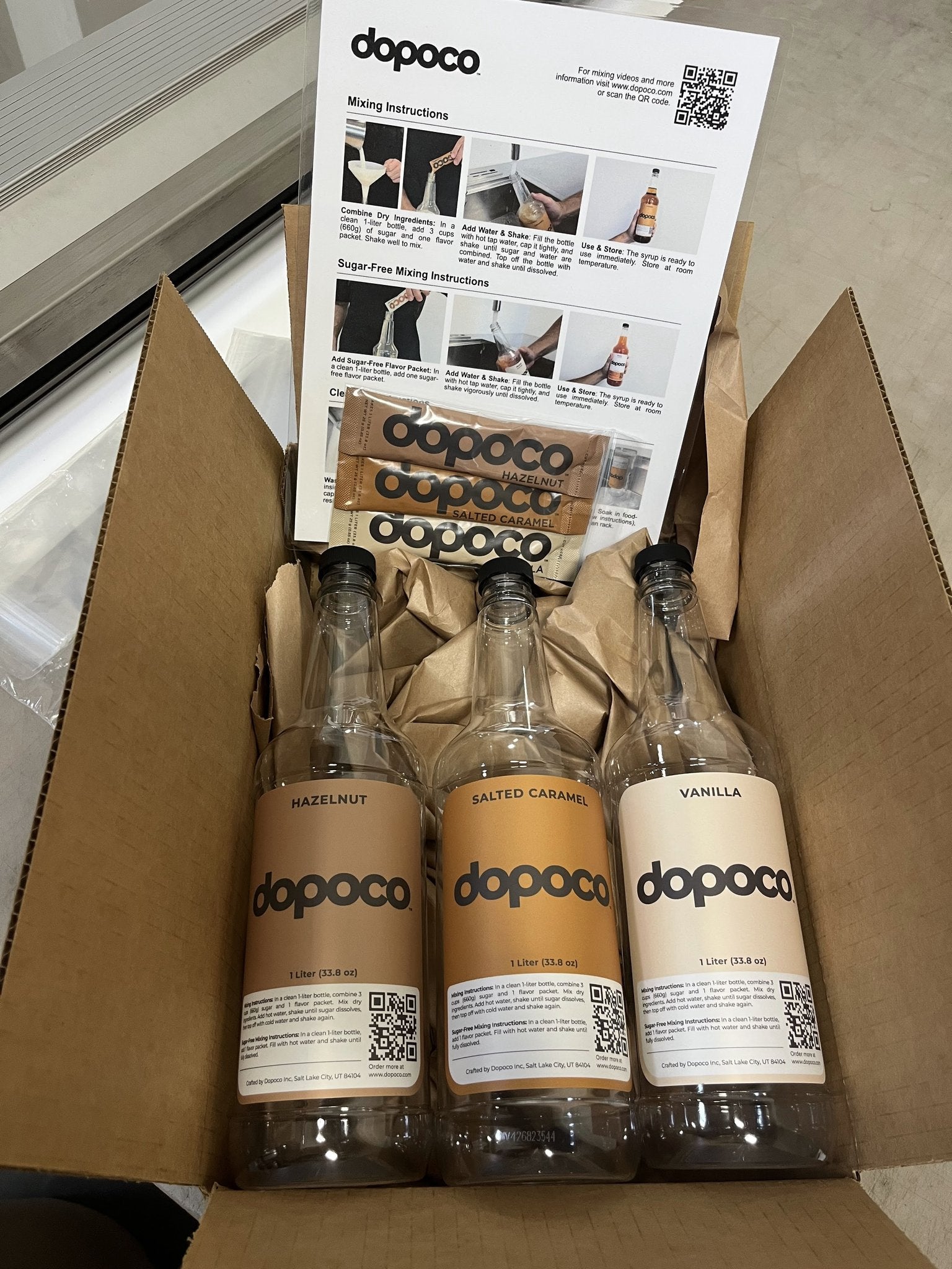 Three dopoco bottles in a cardboard box with packaging materials.