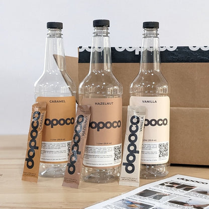 Three bottles of dopoco with packaging and a box on a wooden surface.